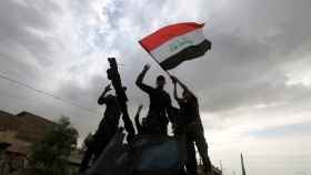 Tropas iraquíes ondean su bandera tras la toma de Mosul.