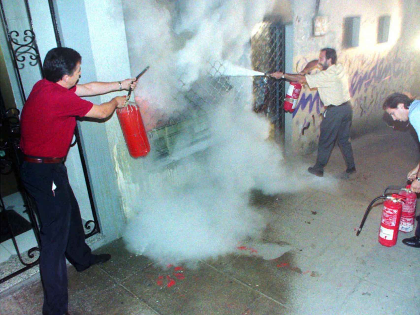 Carlos Totorica, alcalde de Ermua, apagando el fuego de una herriko taberna con un extintor.