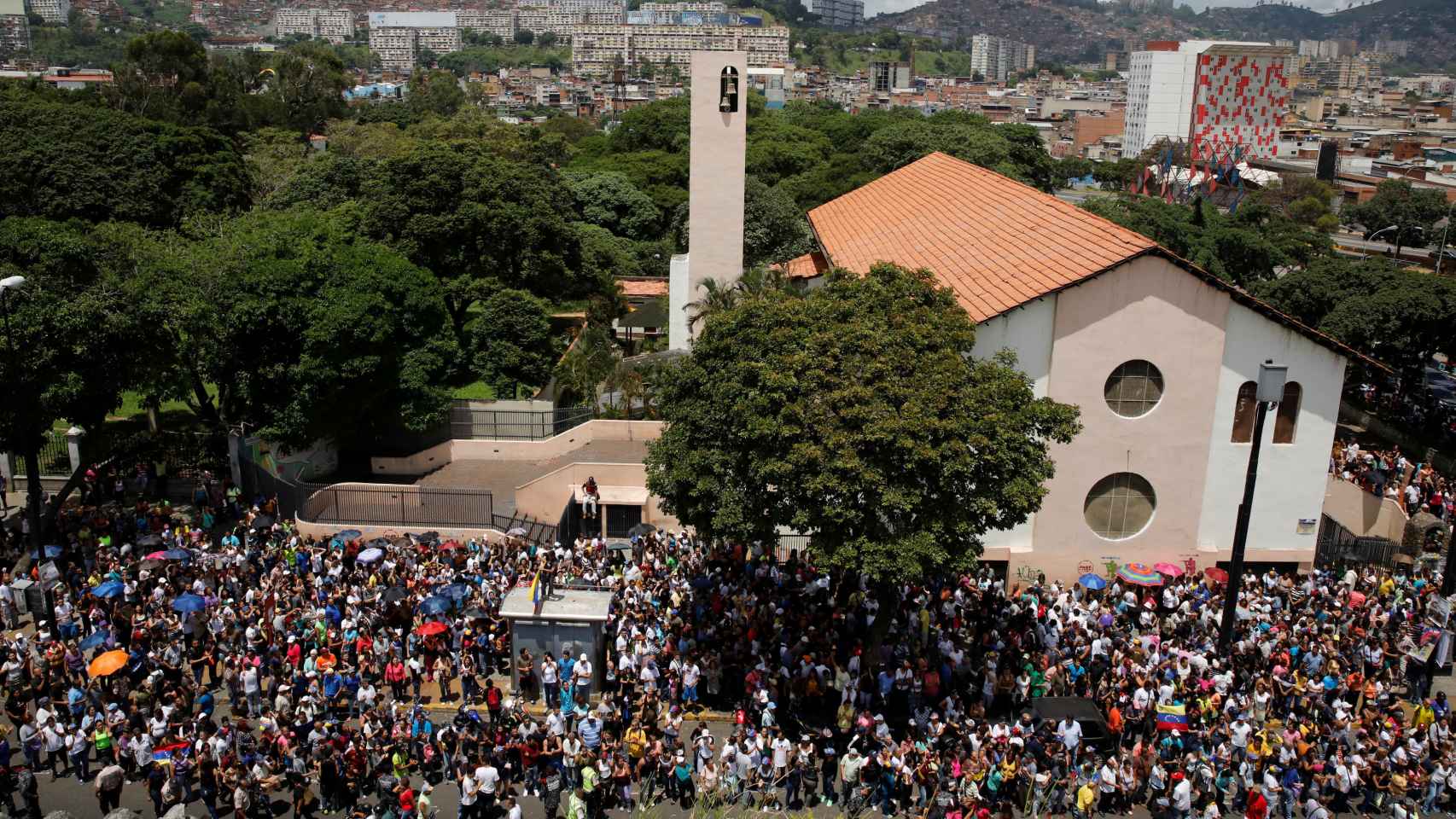 Centeranes de venezolanos se reúnen a las afueras de una iglesia durante el plebiscito.