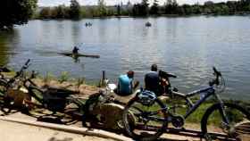 Dos ciclistas descansan junto al lago de la Casa de Campo.