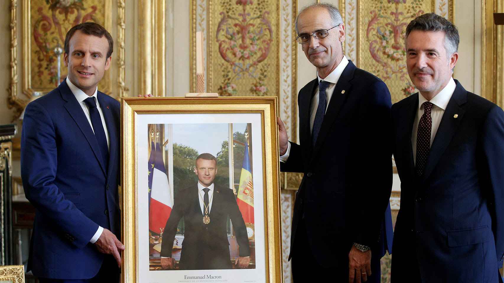 Macron junto a su retrato y los responsables de Andorra