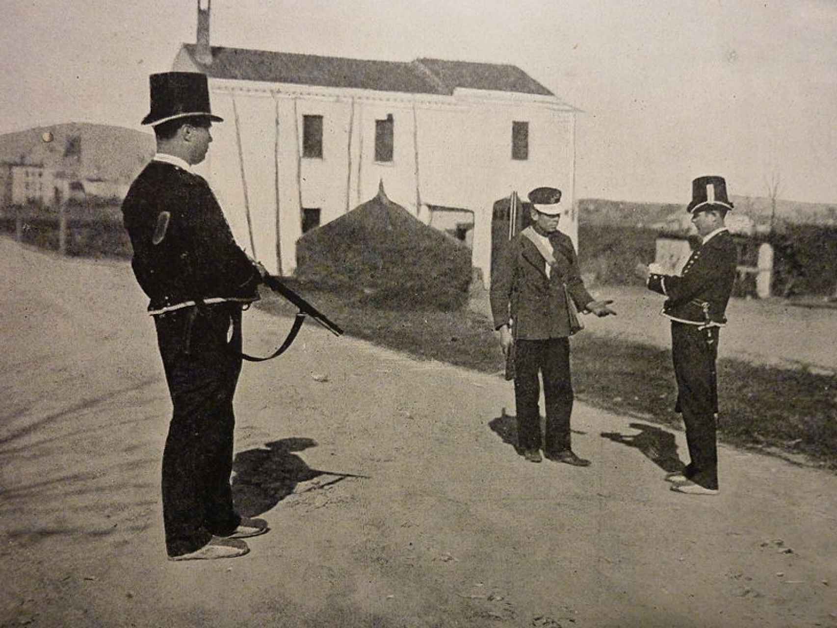 Dos Mossos d'Esquadra haciendo el control de un arma a finales del siglo XIX.