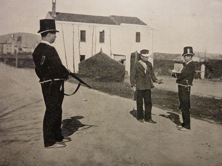 Dos Mossos d'Esquadra haciendo el control de un arma a finales del siglo XIX.