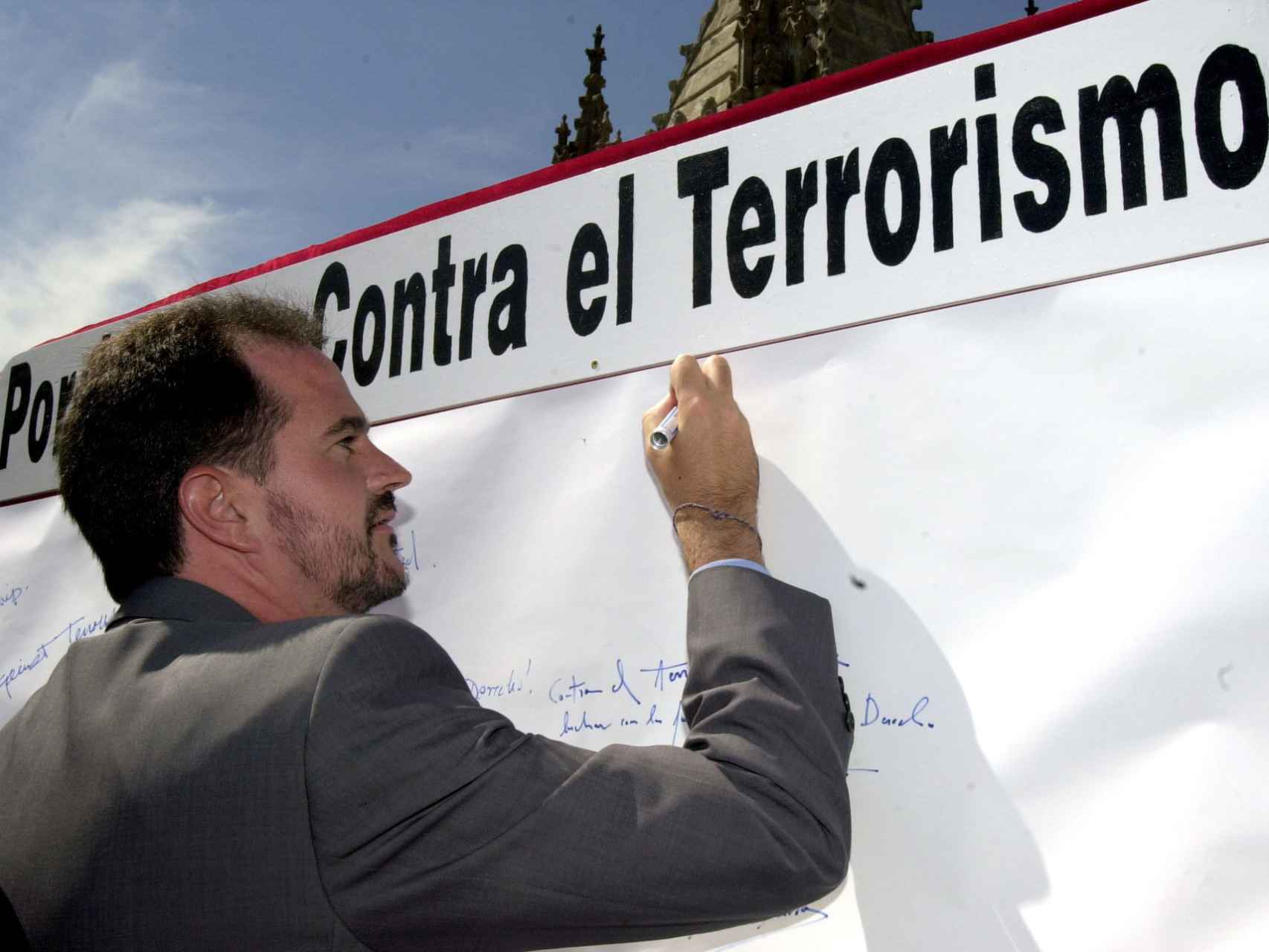 Carlos Iturgaiz en una imagen de 2002 firmando en un panel para expresar su solidaridad con las víctimas del terrorismo.