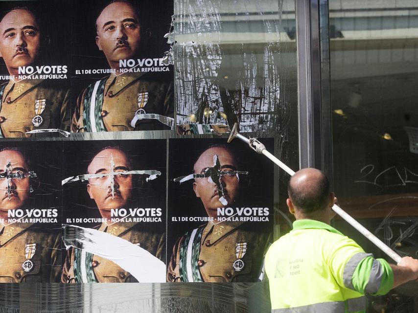 Un operario retira los carteles de la CUP contra los contrarios al referéndum.