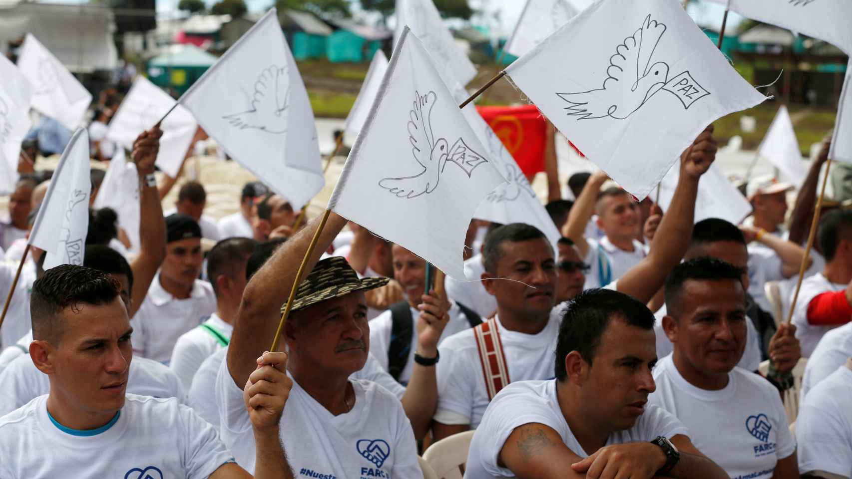 Rebeldes de las FARC portan banderas de la paz durante un acto.