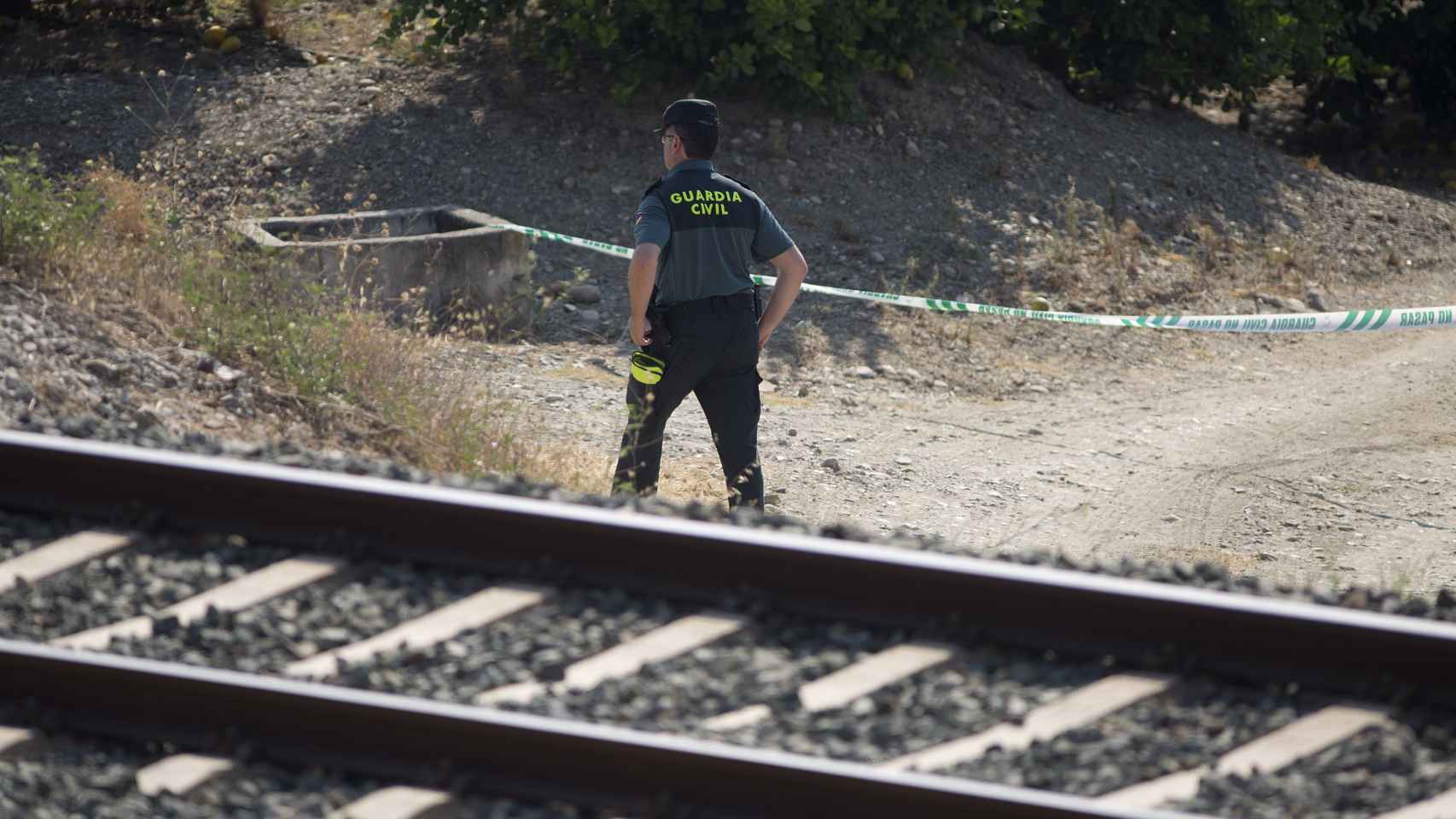 Un guardia civil inspecciona la zona acotada de la vía férrea donde ha sido encontrado el cuerpo de la niña