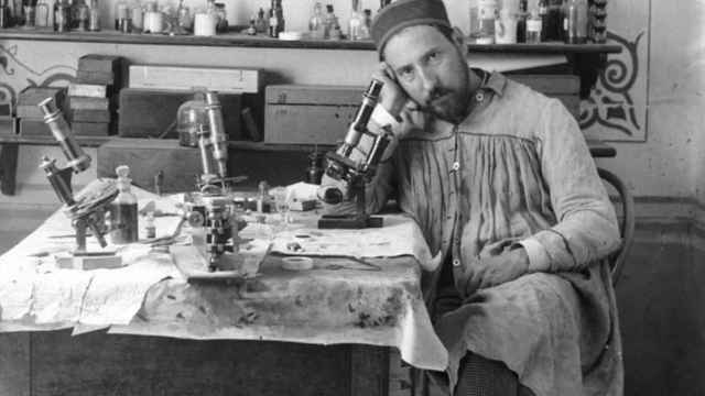 Ramón y Cajal junto a un microscopio en su despacho.