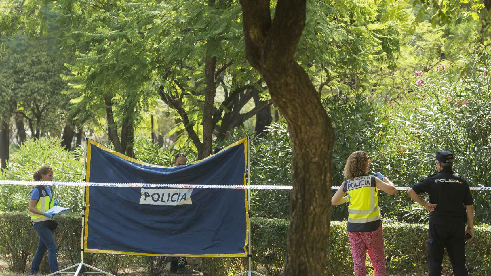 Agentes de Policía Científica y Homicidios inspeccionan el lugar donde han encontrado el cuerpo