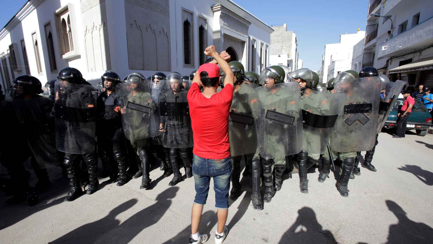 Un manifestante frente a agentes antidisturbios en Alhucemas