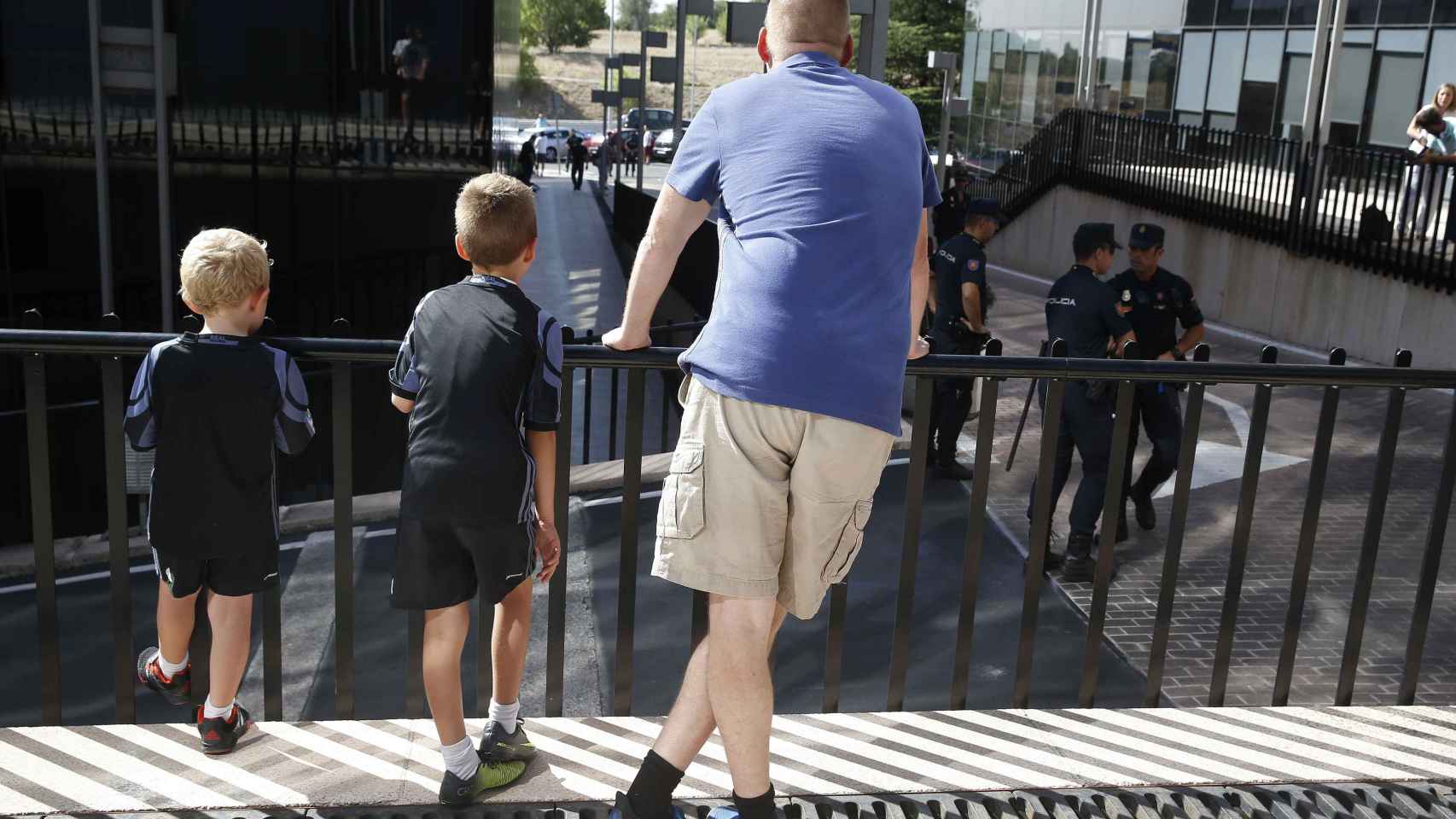 Un padre con sus hijos esperando la llegada del futbolista. EFE