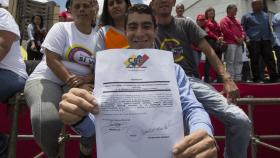 Olivier Guzmán, uno de los miembros de la Constituyente, muestra el documento que lo acredita