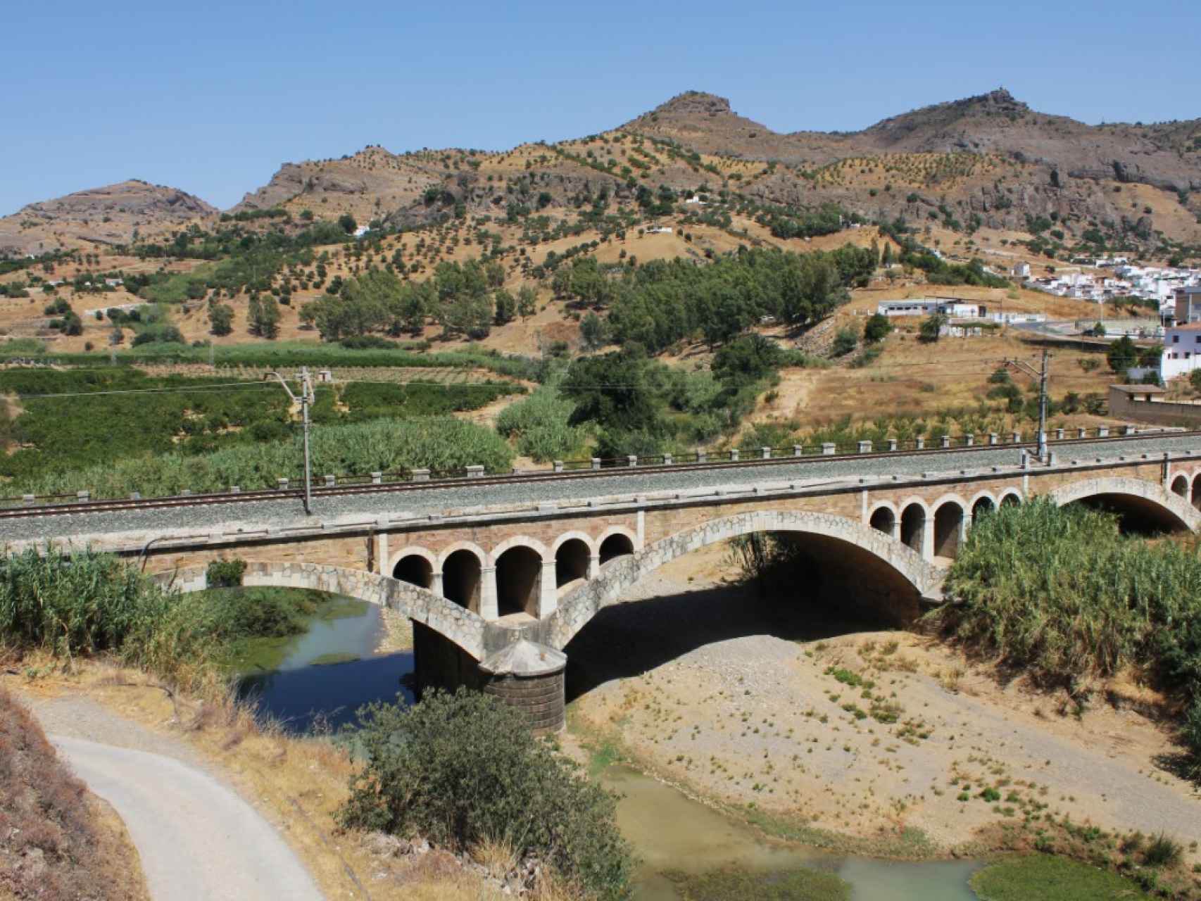 Las vías del tren atraviesan a través de un puente el río Guadalhorce.
