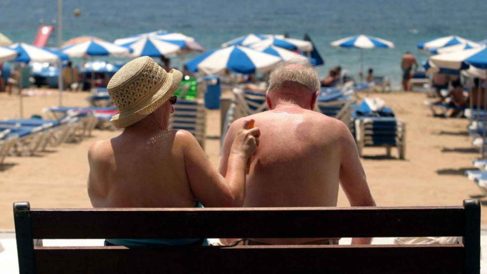 Una pareja de turistas se echa crema en Benidorm, en una imagen de archivo.