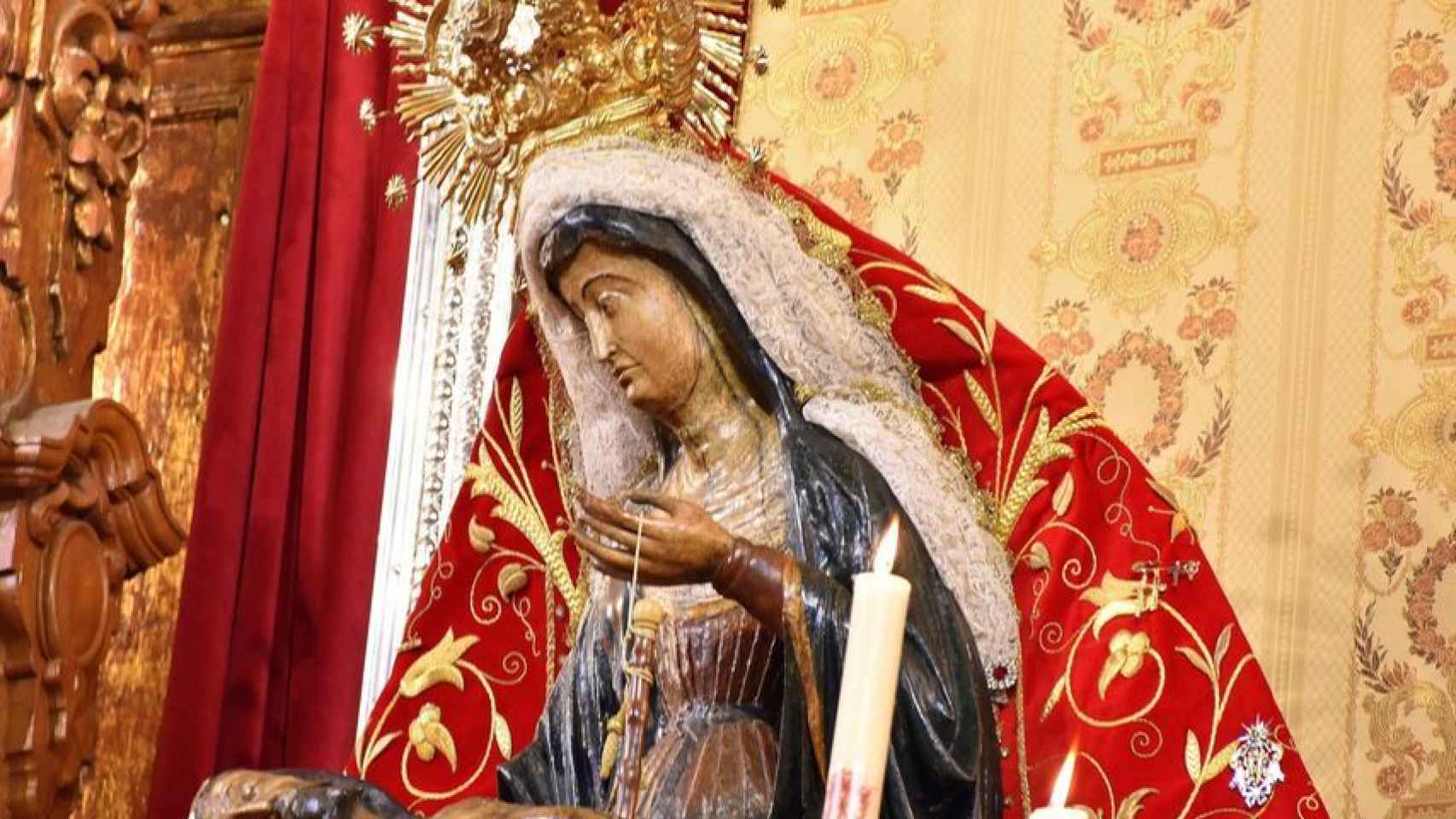 La Virgen con el manto rojo que luce mientras está en el altar de la iglesia.