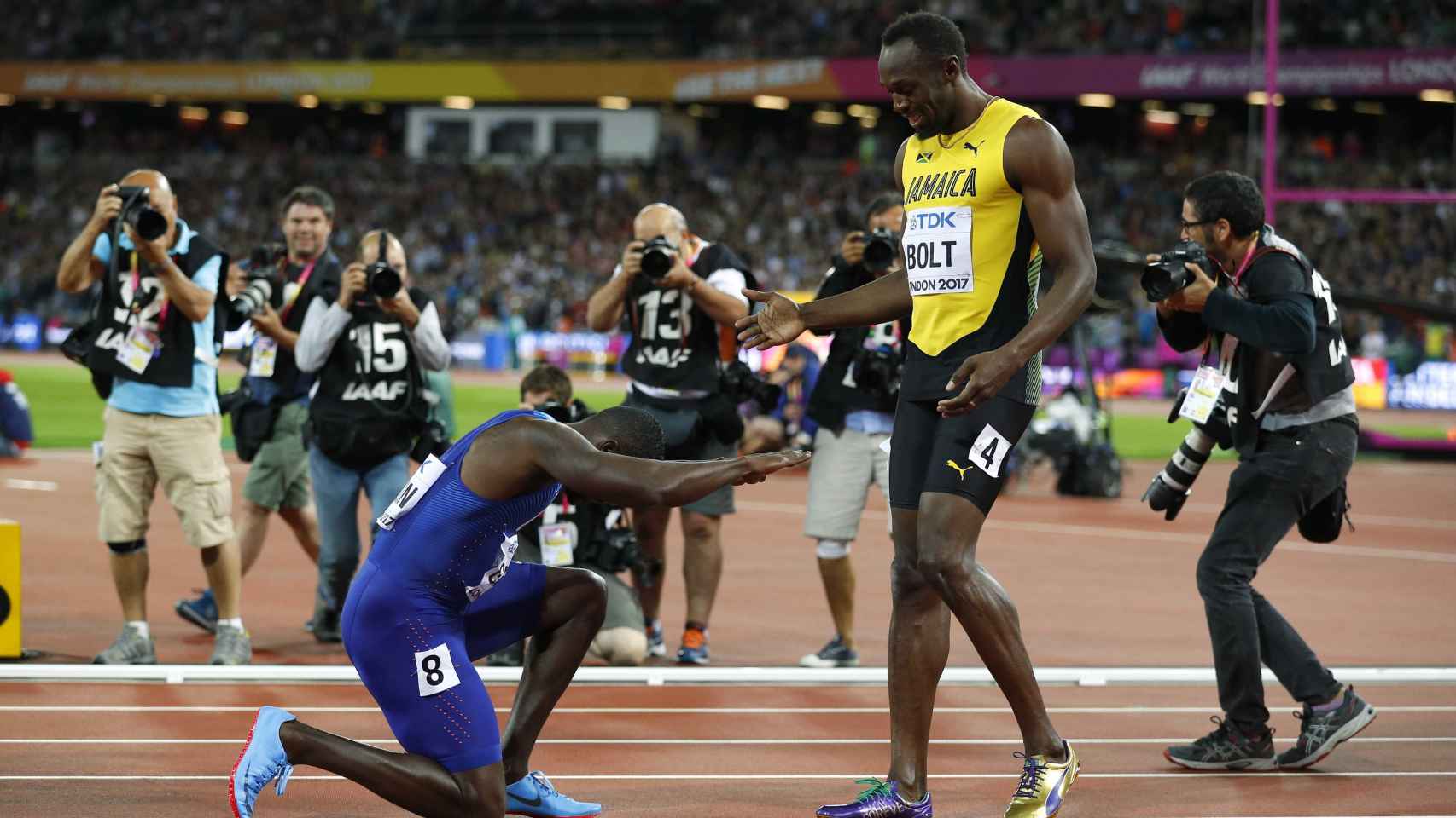 Gatlin hace una reverencia a Bolt tras la final de los 100 metros.