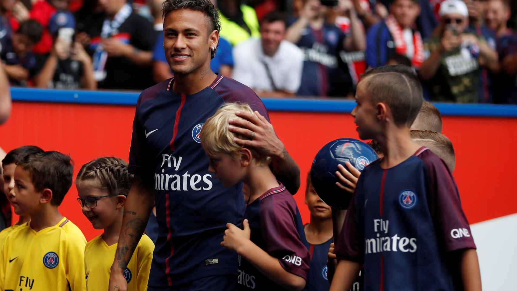 Neymar, con unos niños, en la vuelta que dio al campo saludando a los aficionados.