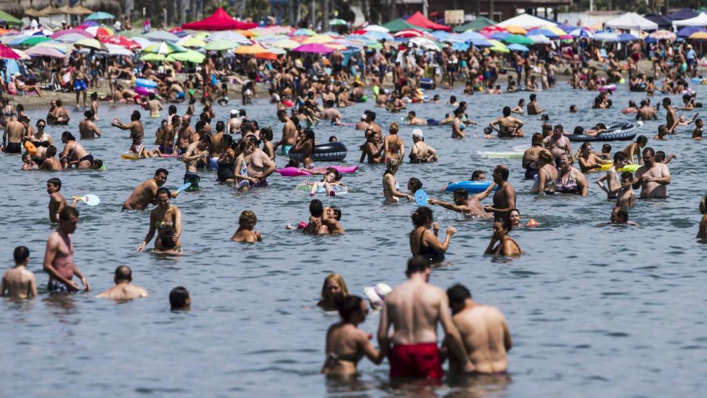 Imagen de archivo de un grupo de personas bañándose en una playa española.