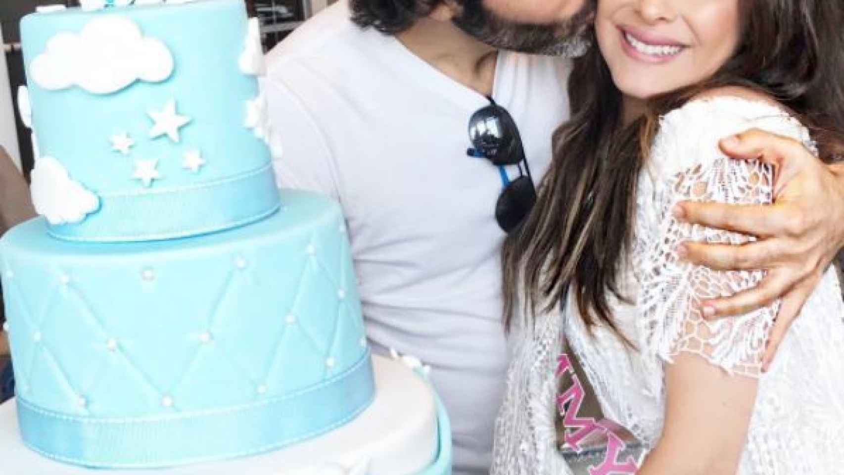 Danna junto al padre de su hijo y la enorme tarta del baby shower.