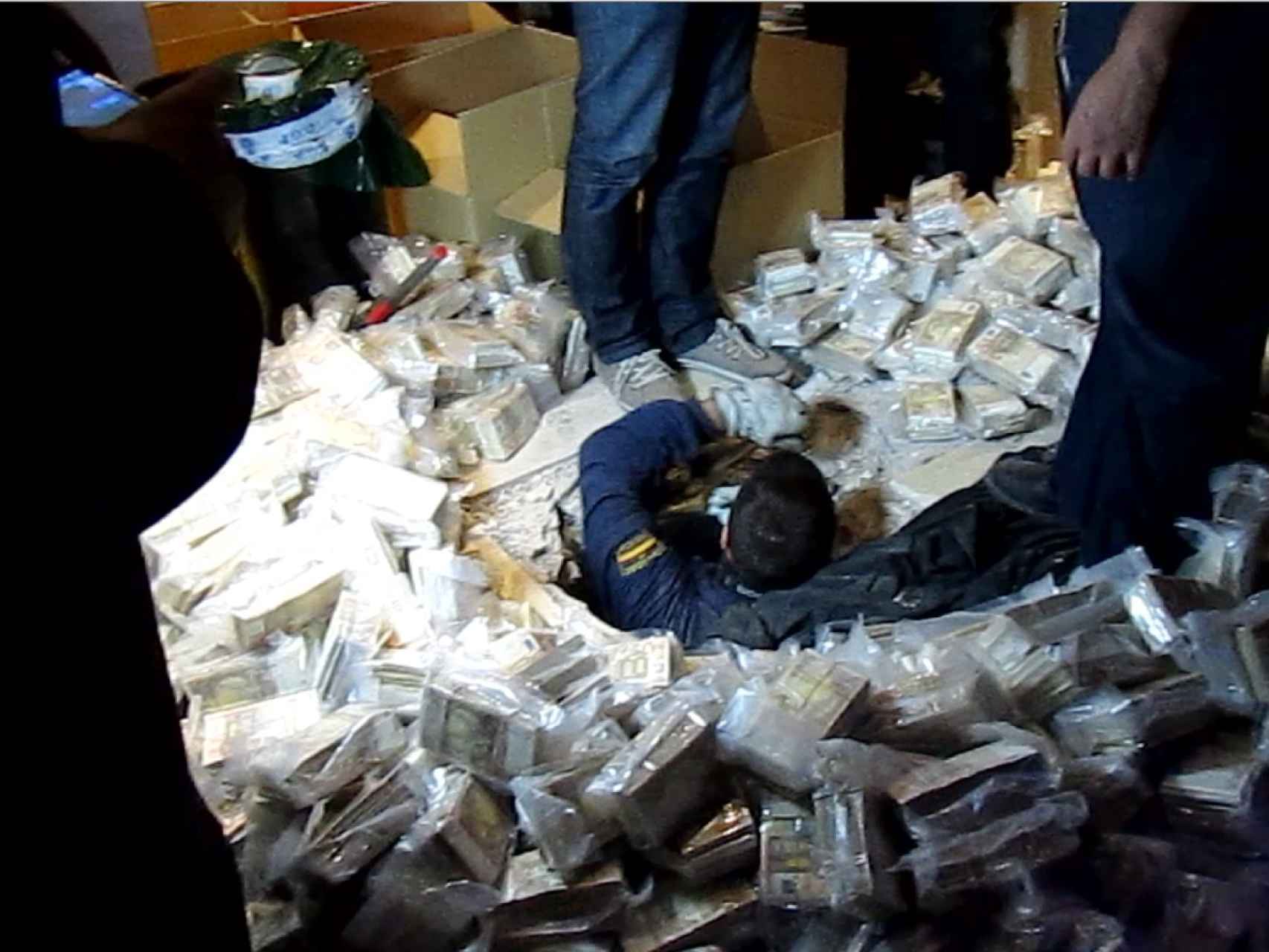 Un agente de la Policía Nacional saca dinero oculto en un zulo de los López Tardón, líderes de Los Miami.