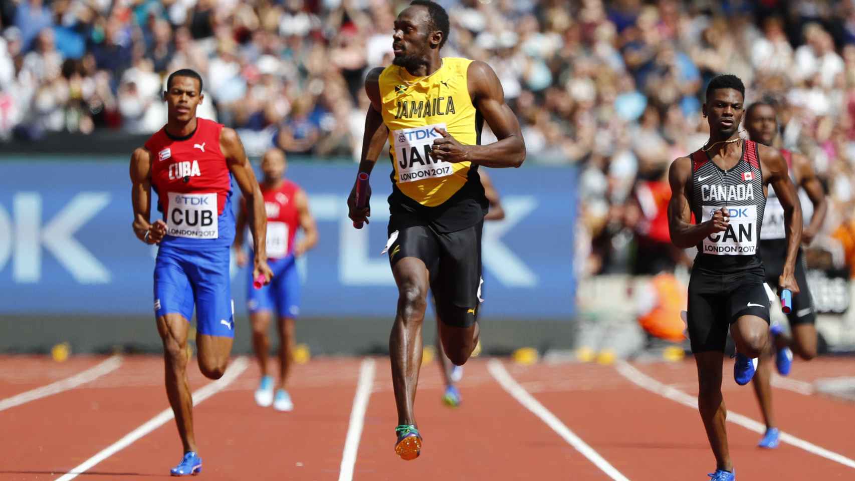 Bolt mira a su derecha controlando a los rivales en la serie del 4x100m.