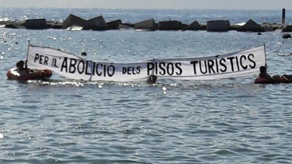 Pancarta que han desplegado en la playa de la Barceloneta.