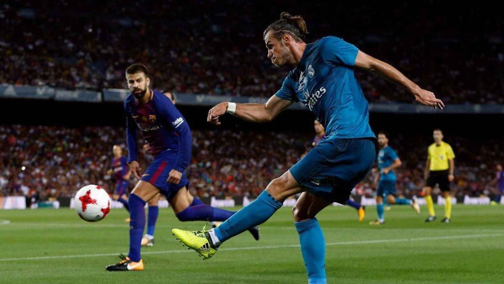 Gareth Bale lanza el esférico ante la mirada de Piqué