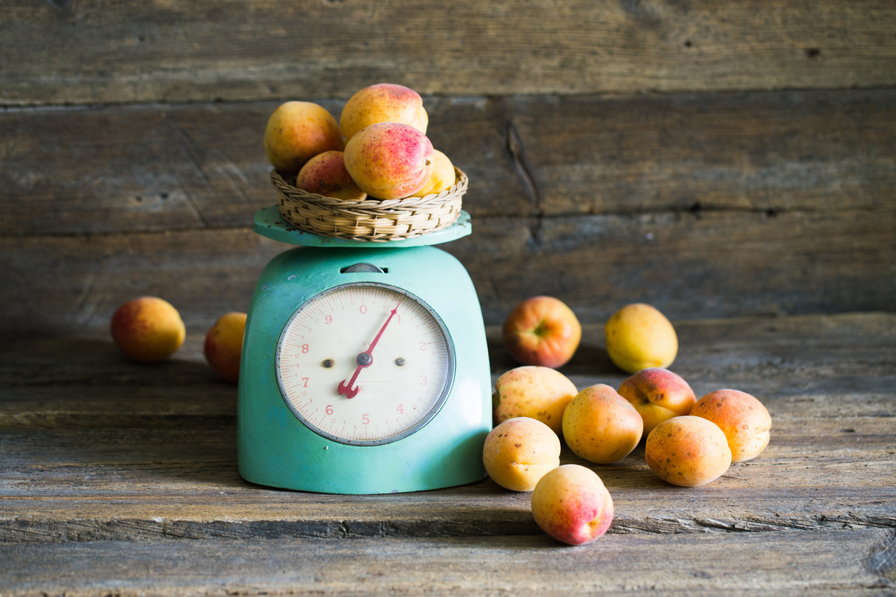 Apricots with kitchen scales on a wood background. toning. Veget