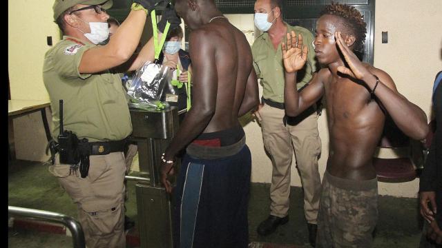 Inmigrantes son atendidos por las autoridades tras cruzar la frontera de Ceuta.