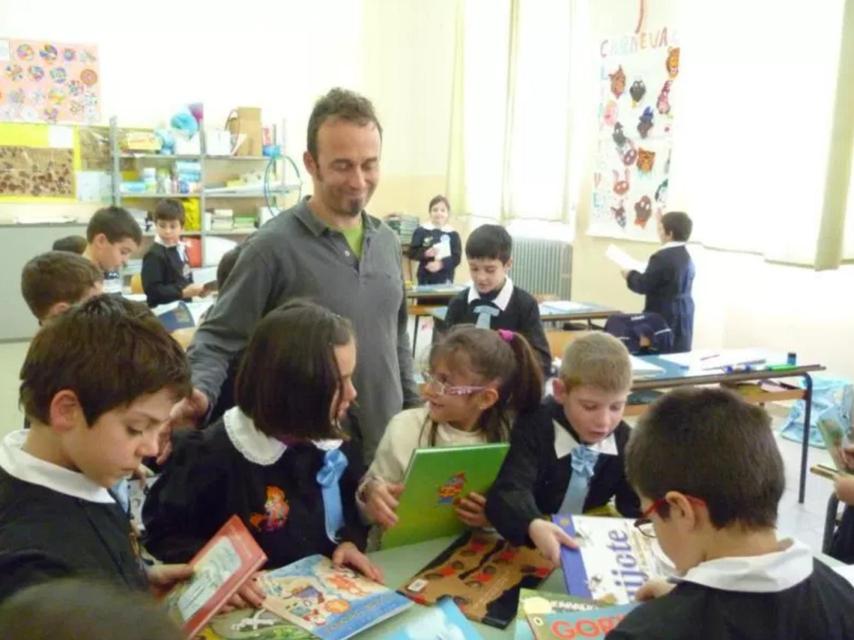 Francesco Arcuri junto a varios niños en el colegio de Carloforte.