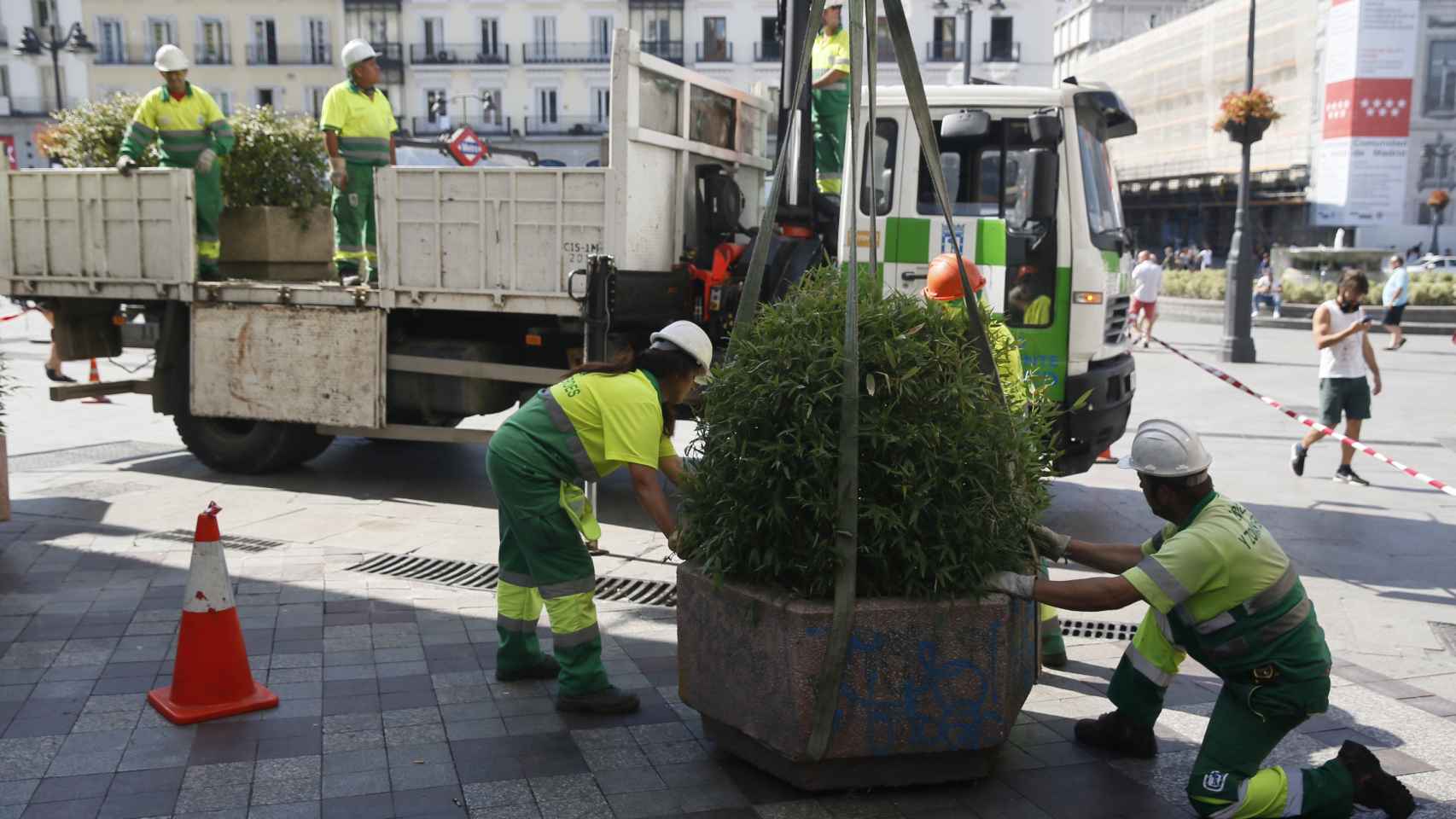 Operarios del Ayuntamiento de Madrid colocan jardineras en la céntrica Calle de Montera