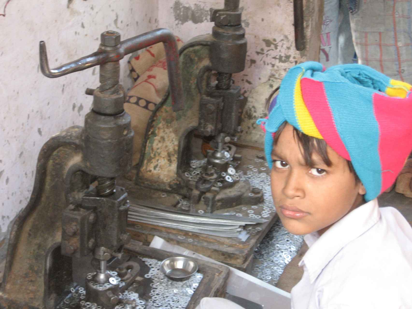 Tanvir, 9 años, gana poco más de un euro al día por fabricar 4000 arandelas