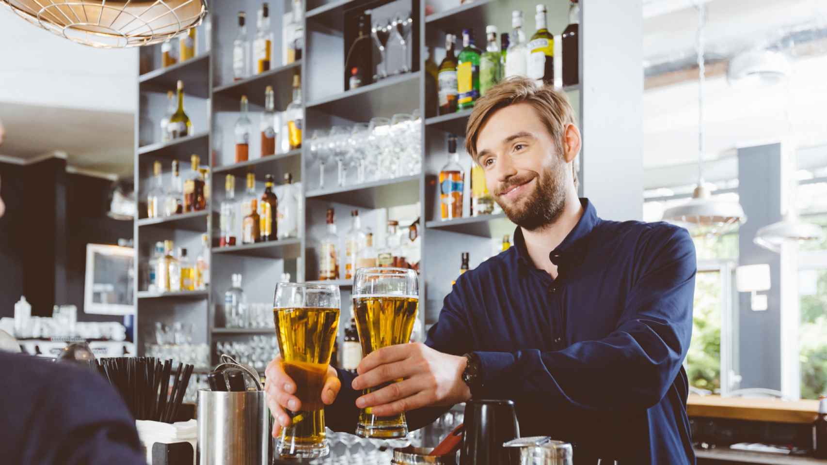 Barman serving beer in a pub