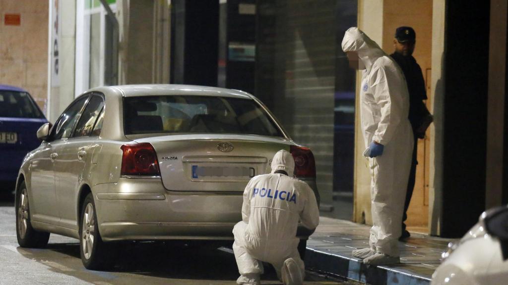 Agentes de la Policía científica recogen muestras en la puerta del domicilio de Elda.