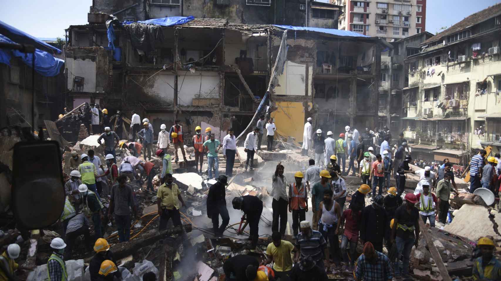 Miembros de los servicios de búsqueda y rescate buscan supervivientes entre los escombros tras derrumbarse un edificio en Bombay .