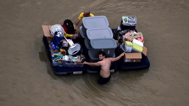 Afectados por las inundaciones tratan de salvar sus pertenencias.