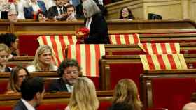 Una diputada de Podemos retira las banderas de España del Parlament.