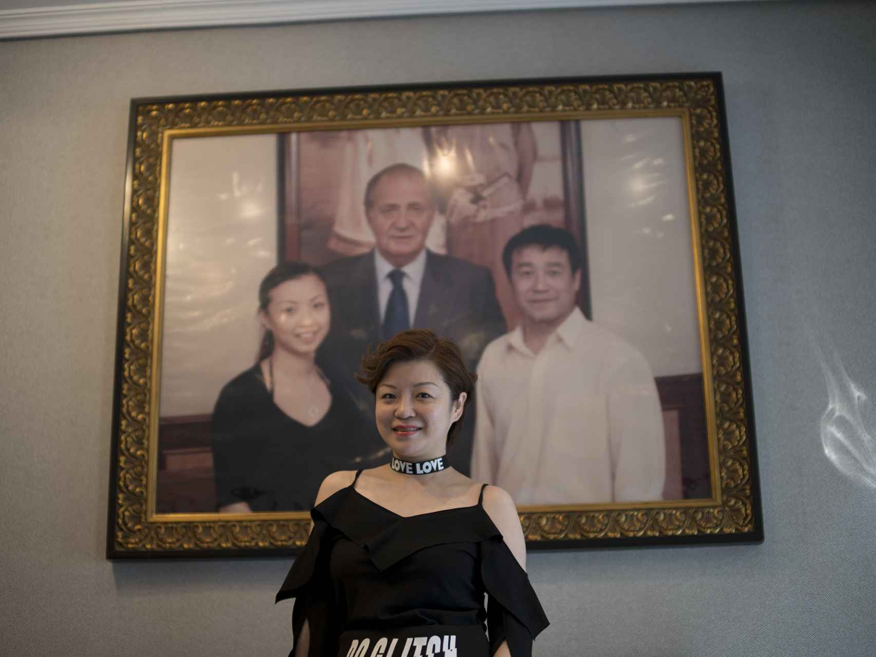 Anna Wu, junto a la foto del rey a la entrada de su restaurante chino.