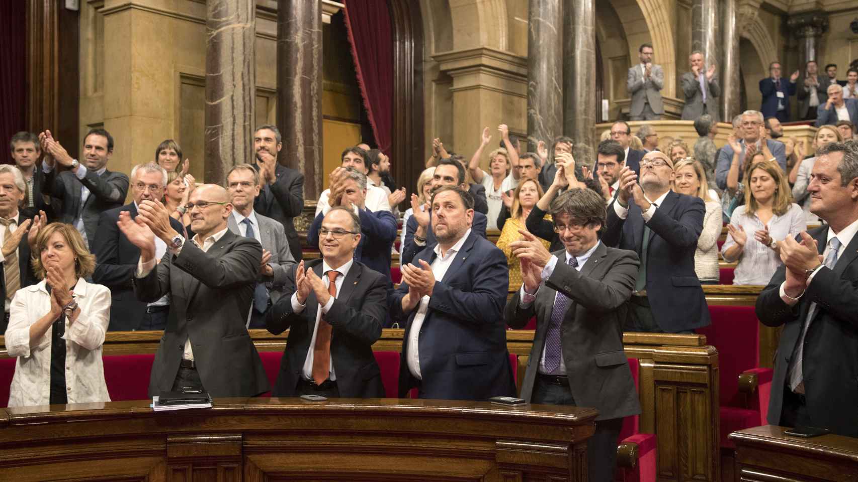 Puigdemont y Junqueras aplauden tras la aprobación de la ley.
