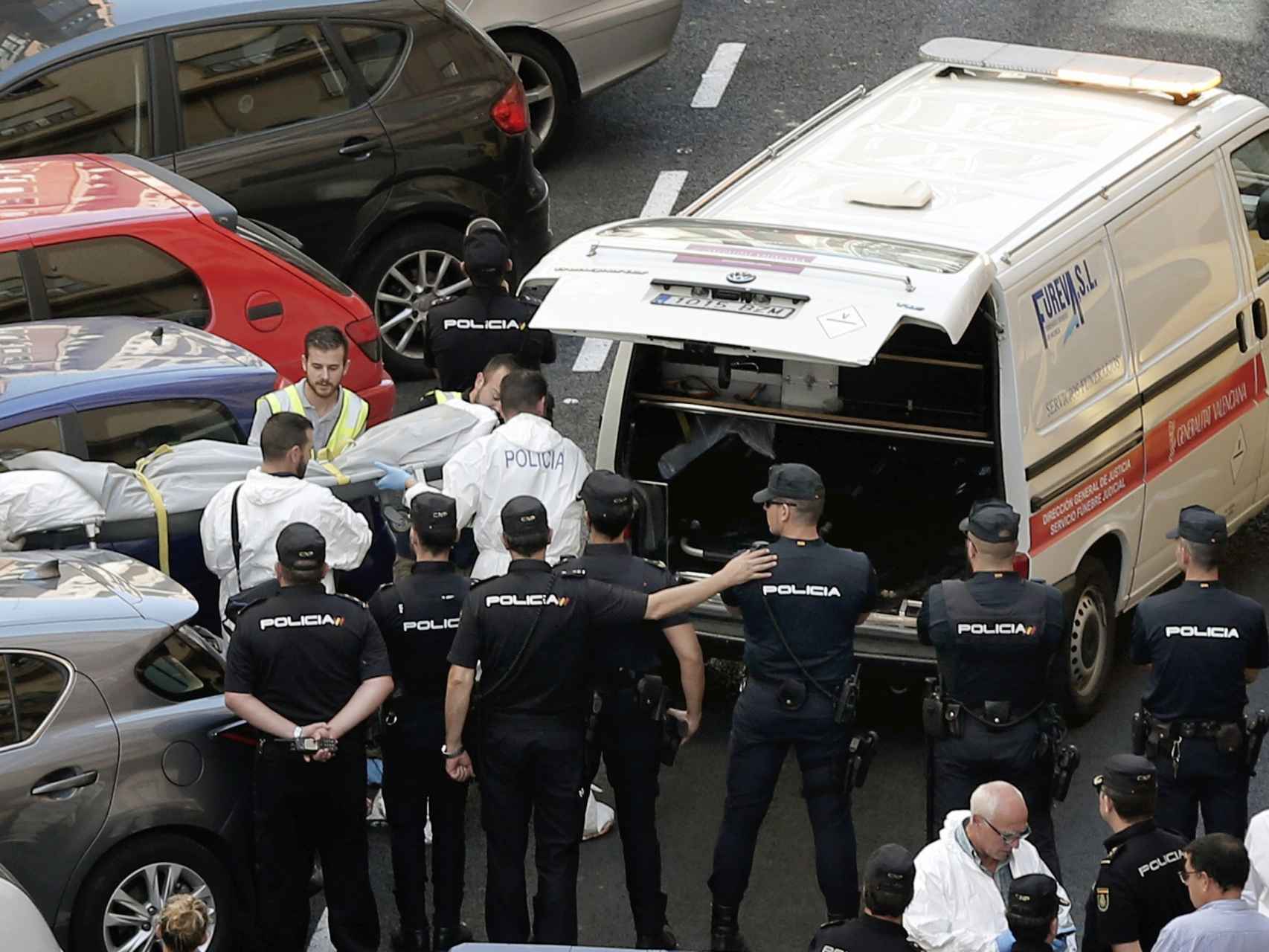 Funcionarios judiciales trasladan el cuerpo sin vida de una de las dos personas que han fallecido en la calle Sueca.