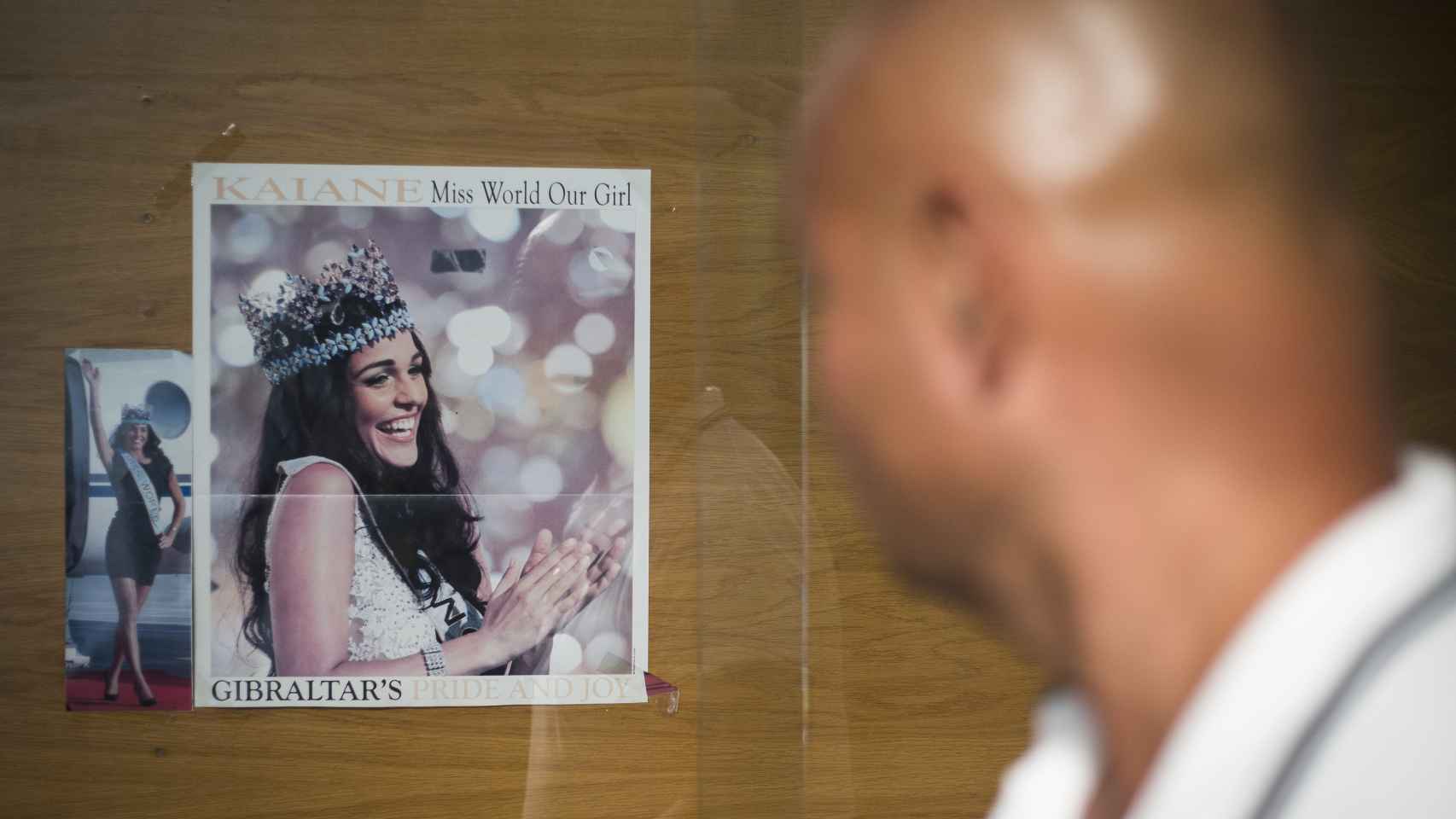 La foto de la gibraltareña Kaiane Aldorino en el momento de proclamarse Miss Mundo es la primera imagen que encuentran los visitantes al cruzar la frontera desde España, colgada en un tablón