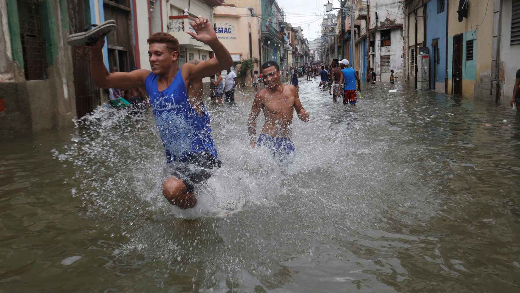 Un joven cubano corre por una calle inundada de La Habana.