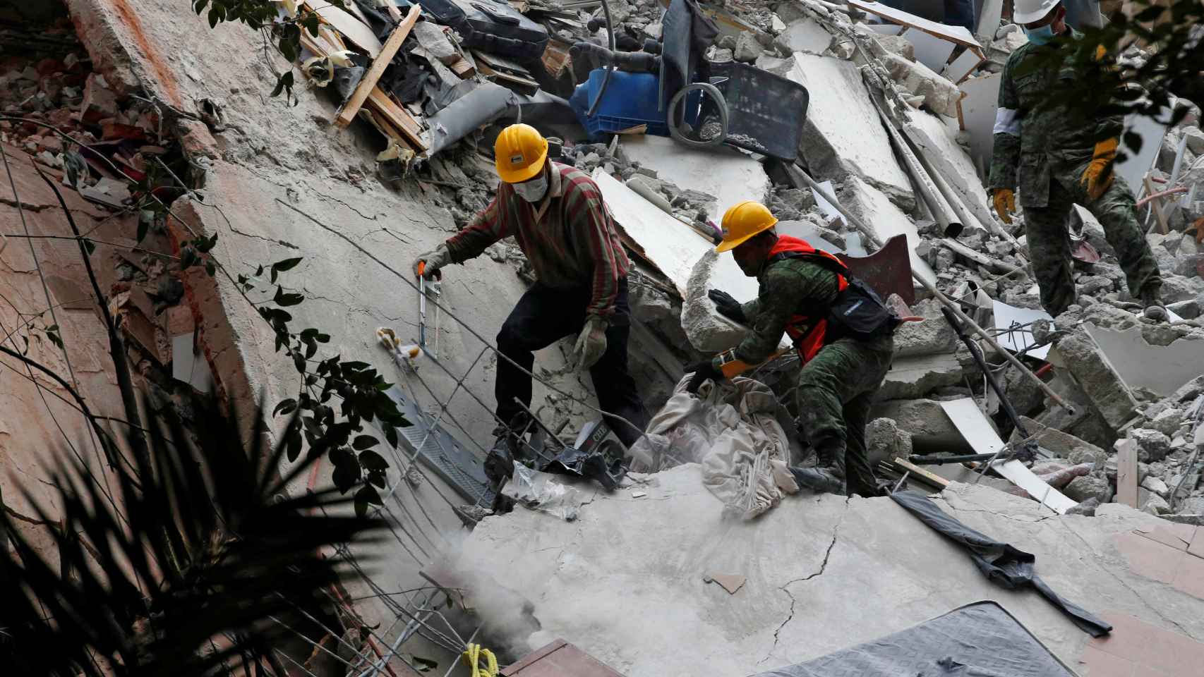 Los equipos de rescate buscan supervivientes en los escombros de un edificio.