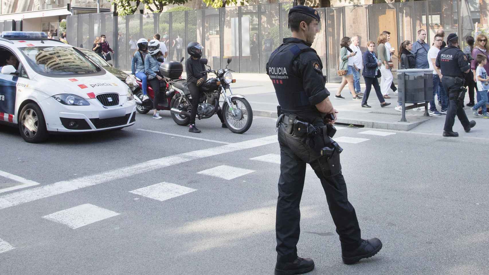 Un Mosso patrulla por una calle.