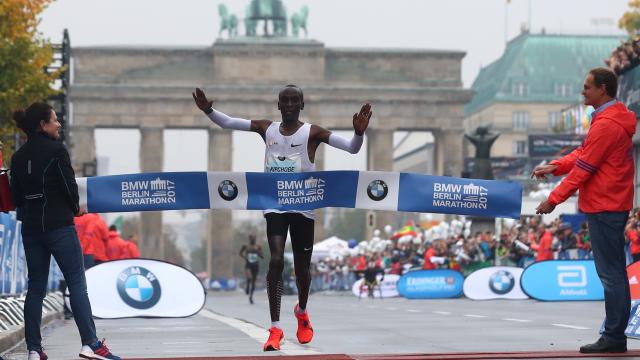 Kipchoge cruza la meta con la Puerta de Brandenburgo al fondo.