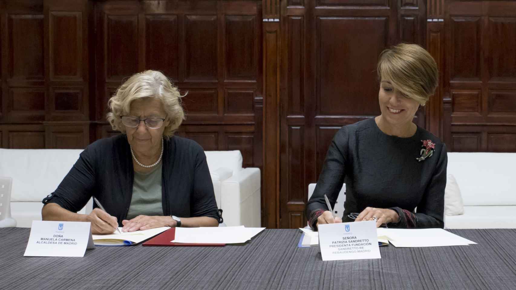 Manuela Carmena y Patrizia Sandretto firmando la cesión.
