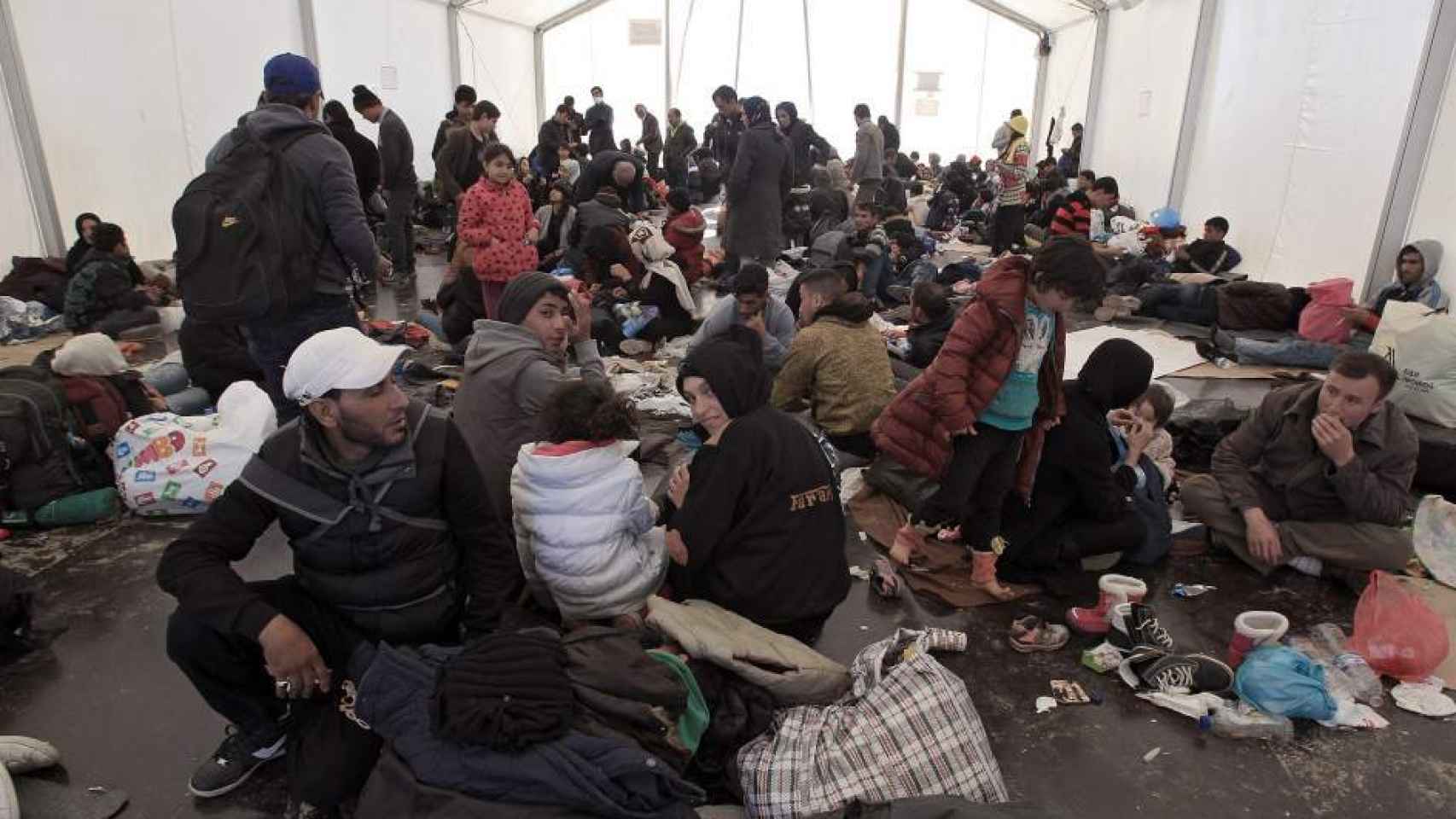 Un grupo de refugiados esperan en un campamento de Lesbos.