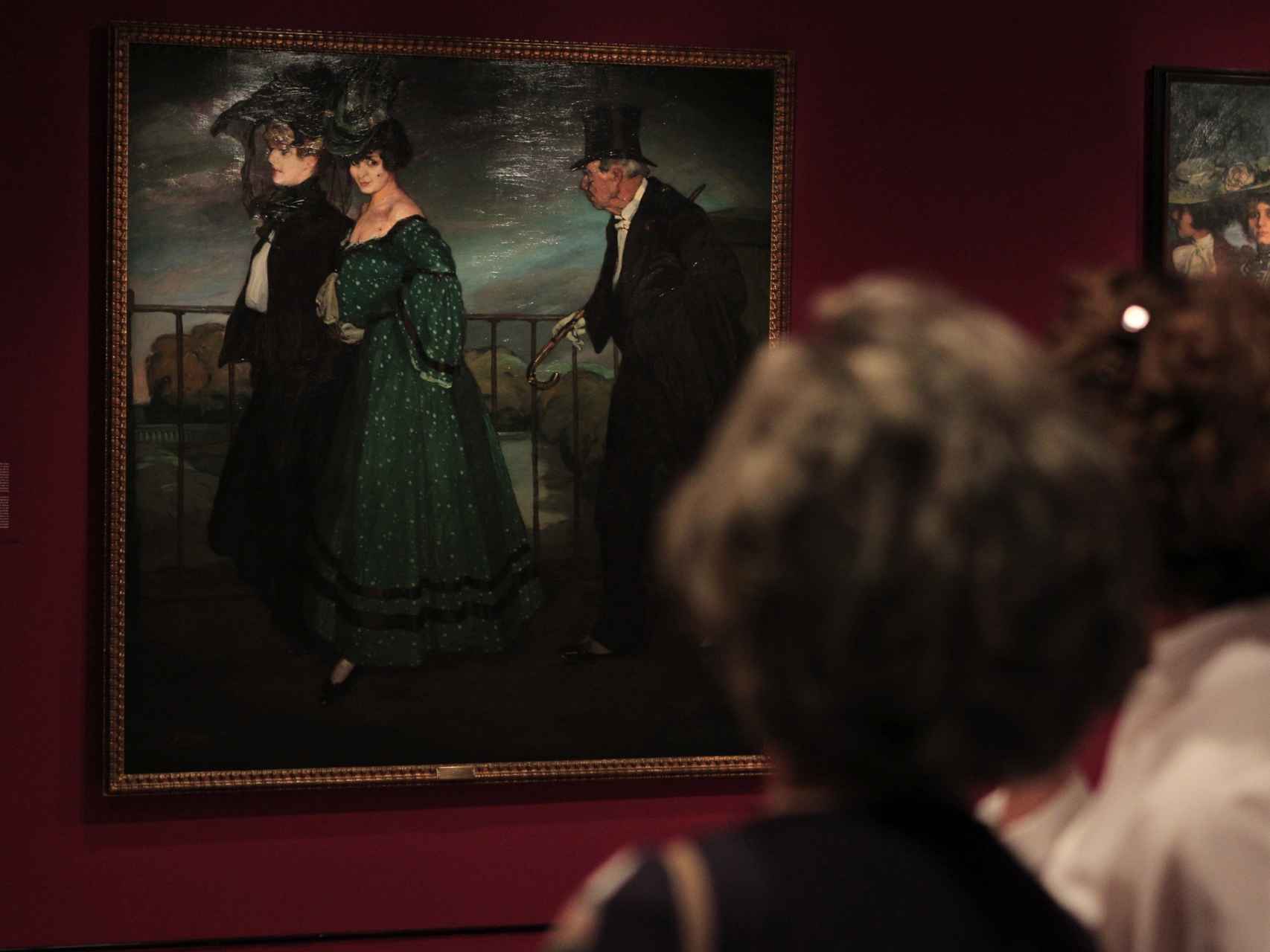 Dos visitantes ante una de las pinturas de la exposición.