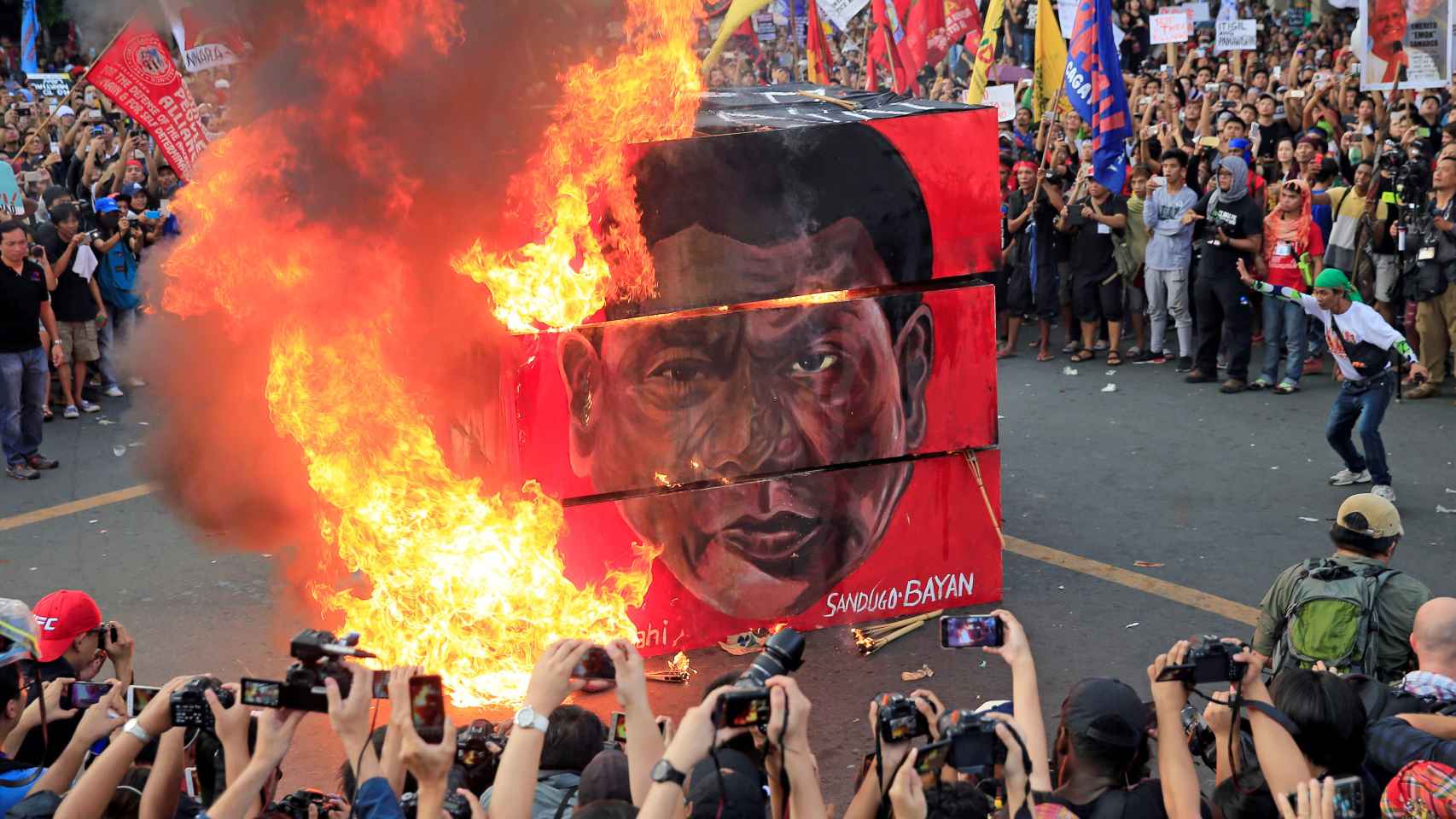 Manifestantes queman una imagen con la cara de Rodrigo Duterte.