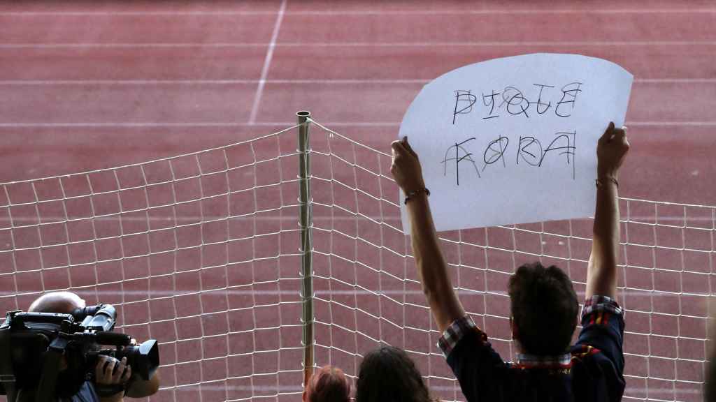 Un aficionado muestra una pancarta en la que se puede leer 'Piqué fora'.